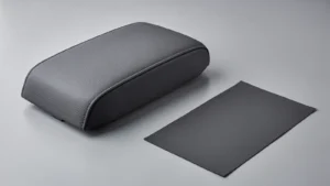 Dark gray upholstered armrest form beside a rectangular material swatch