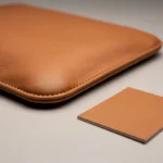 Close view of a rounded stitched cognac flap corner beside a flat swatch